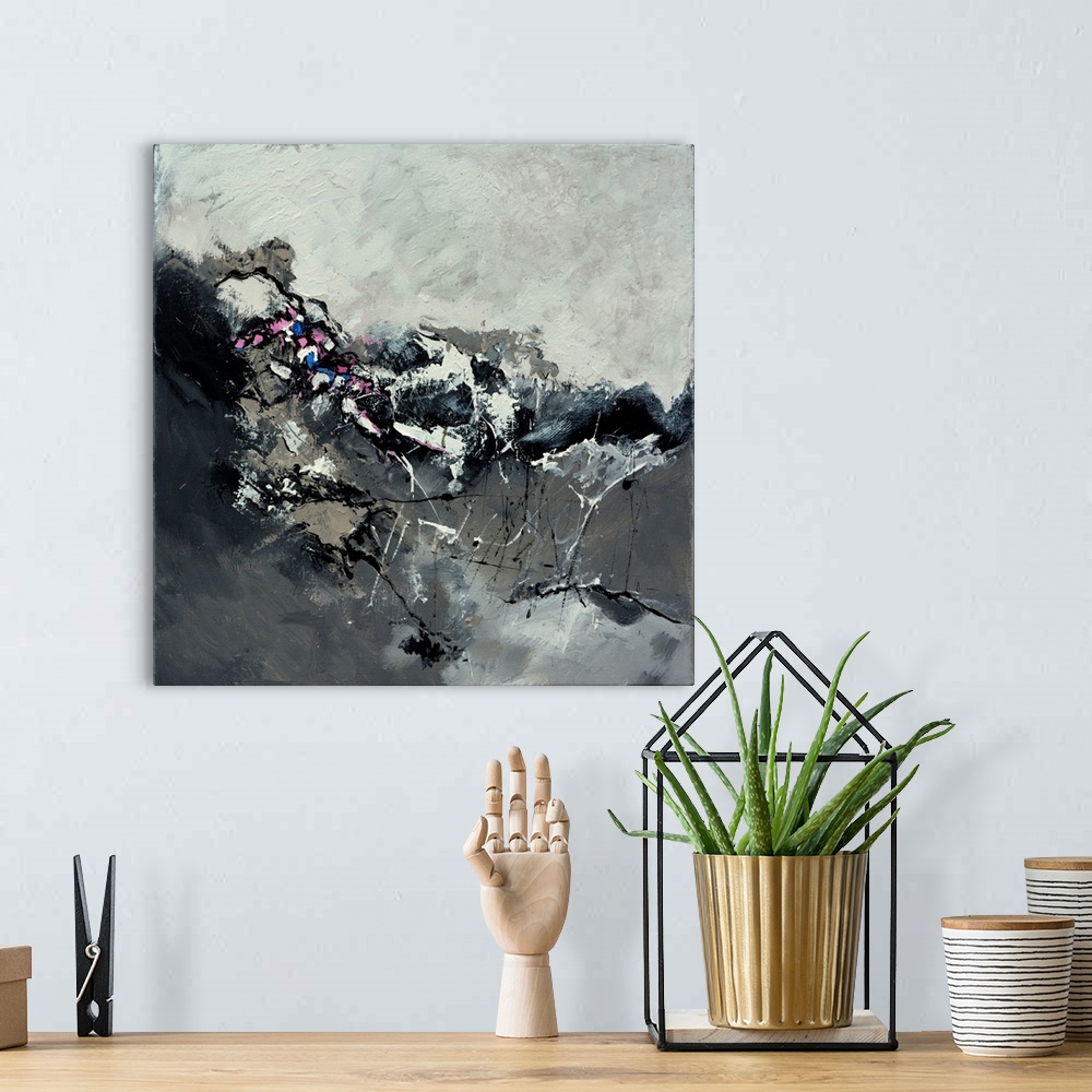 A bohemian room featuring A square abstract painting in shades of black and gray with splatters of paint overlapping.