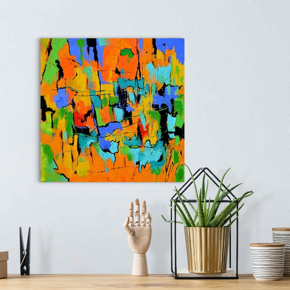 A bohemian room featuring A square abstract painting in textured shades of orange, blue, green and yellow with splatters of...