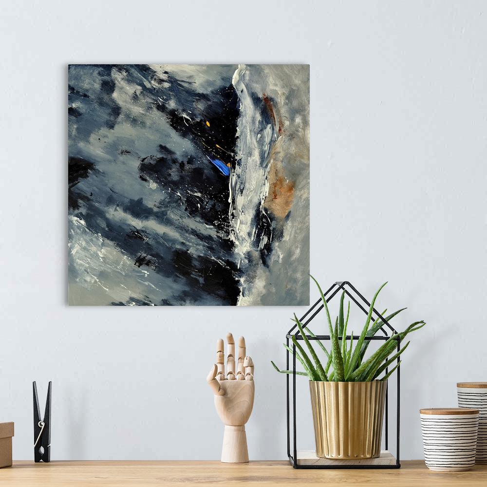 A bohemian room featuring A square abstract painting of colors of gray, white and blue in bold brush strokes and splattered...