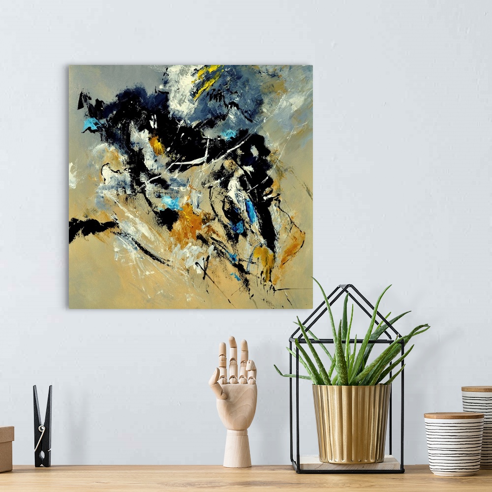 A bohemian room featuring A square abstract painting in dark shades of black, blue, white and yellow with splatters of pain...