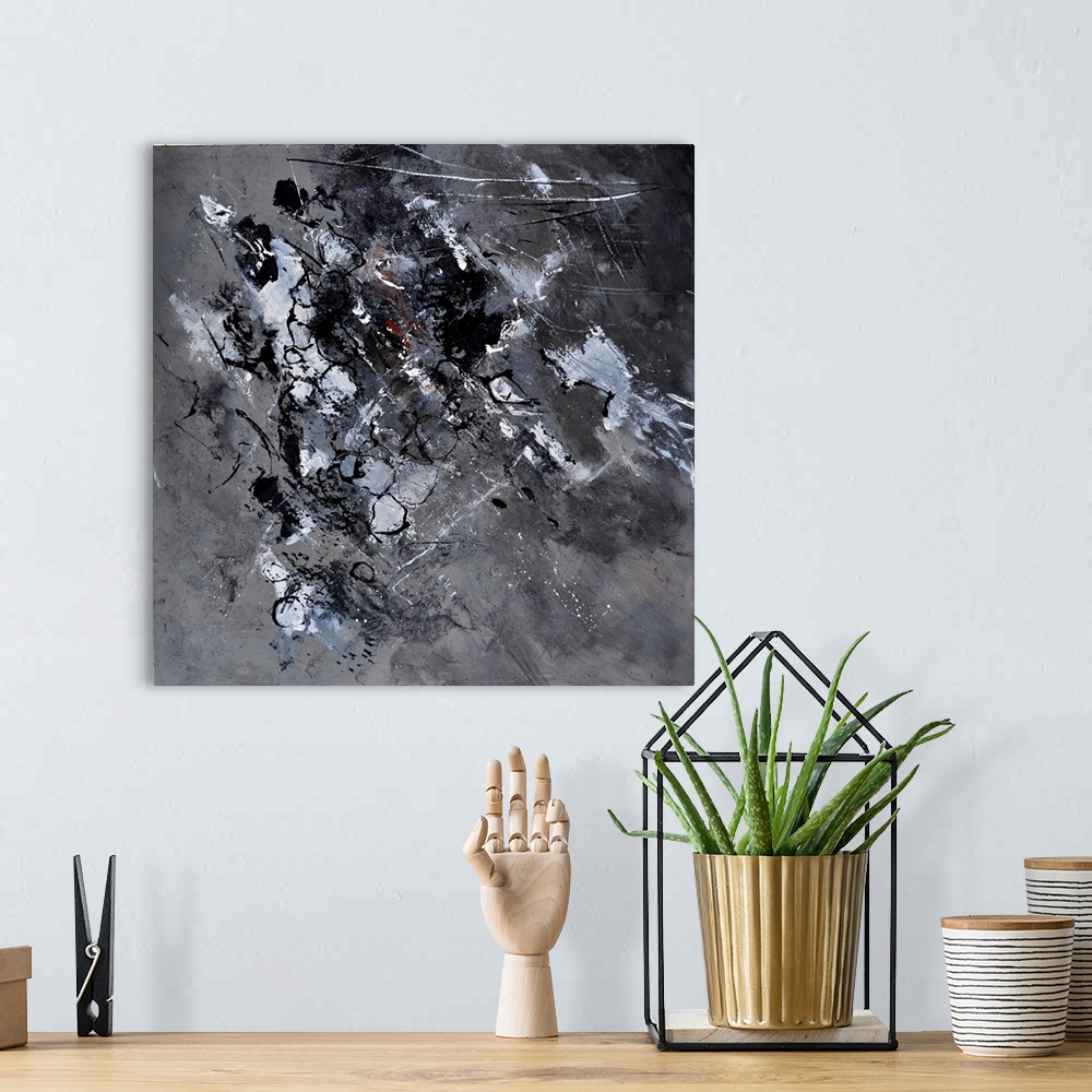 A bohemian room featuring A square abstract painting in dark colors of white, gray and black with splatters of paint overla...