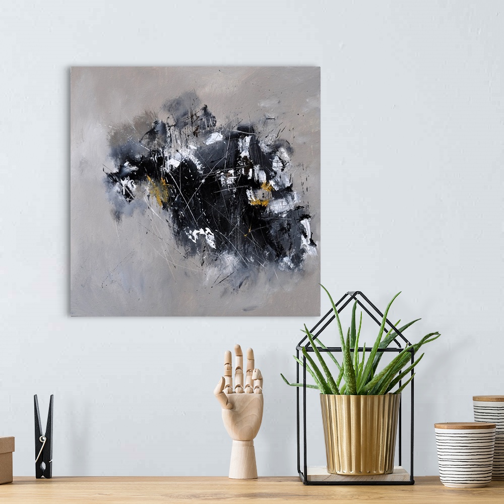 A bohemian room featuring A square abstract painting in textured shades of black and gray with splatters of paint overlapping.