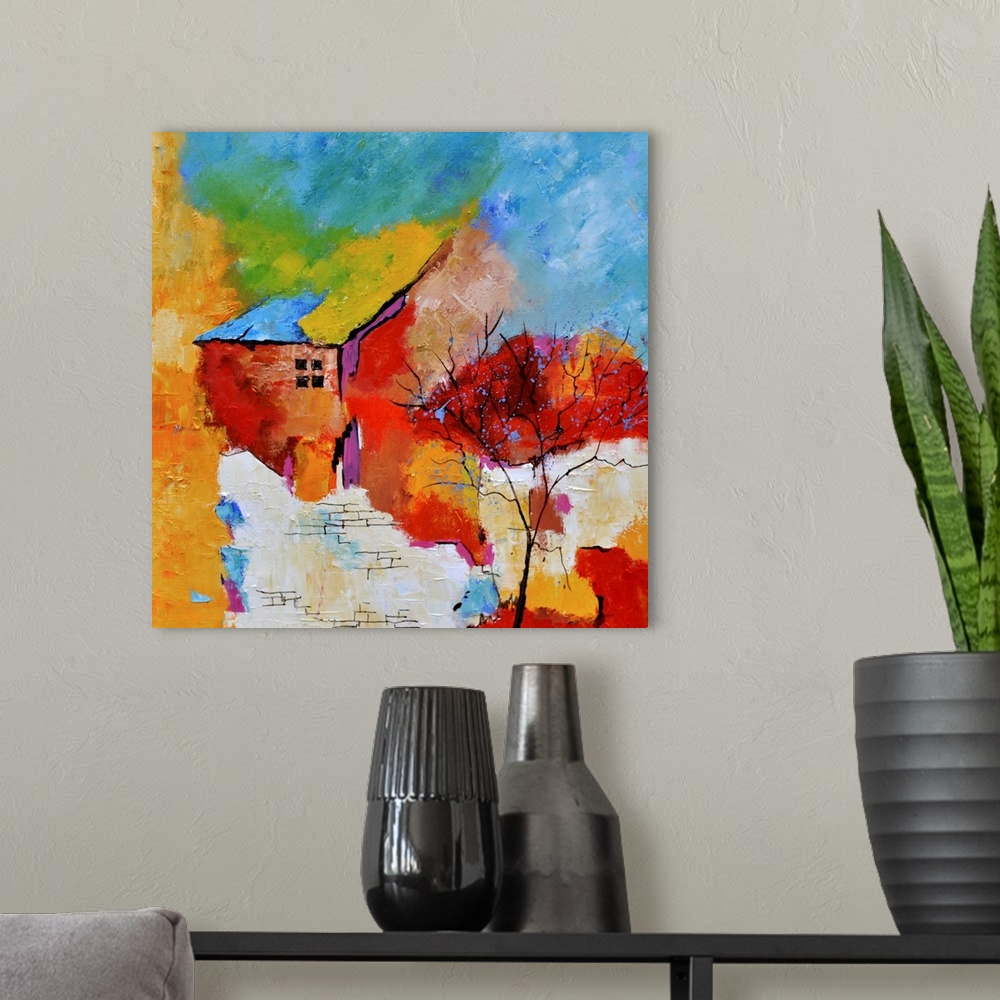 A modern room featuring A square abstract painting of a house with vibrant textured colors of red, yellow and blue.