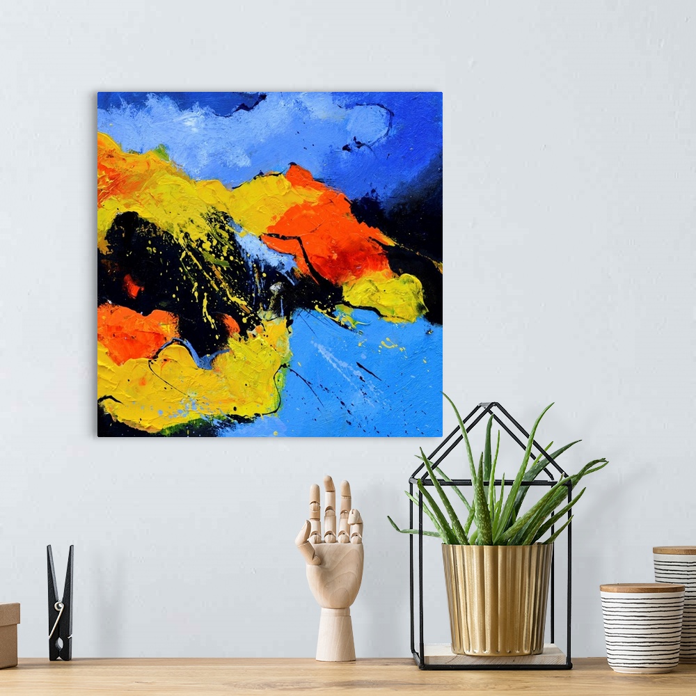 A bohemian room featuring A square abstract painting in vibrant shades of black, blue, orange and yellow with splatters of ...