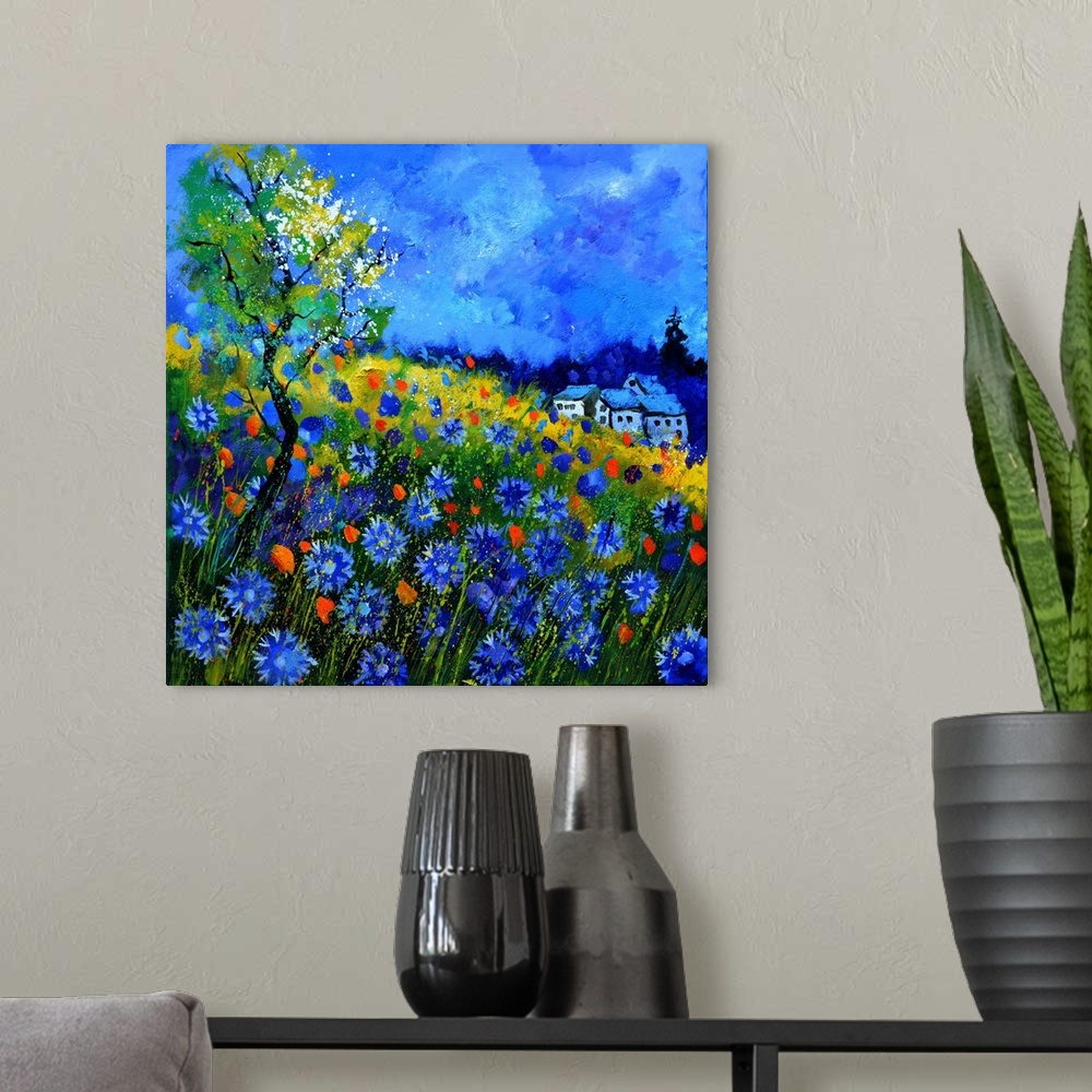 A modern room featuring Vibrant painting of a bright Summer day with blossoming flowers, a colorful sky, and a house in t...