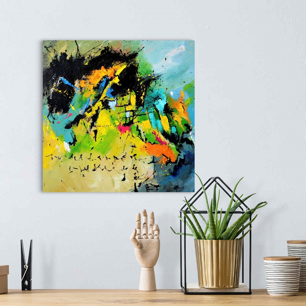 A bohemian room featuring A square abstract painting in dark shades of black, blue, green and yellow with splatters of pain...