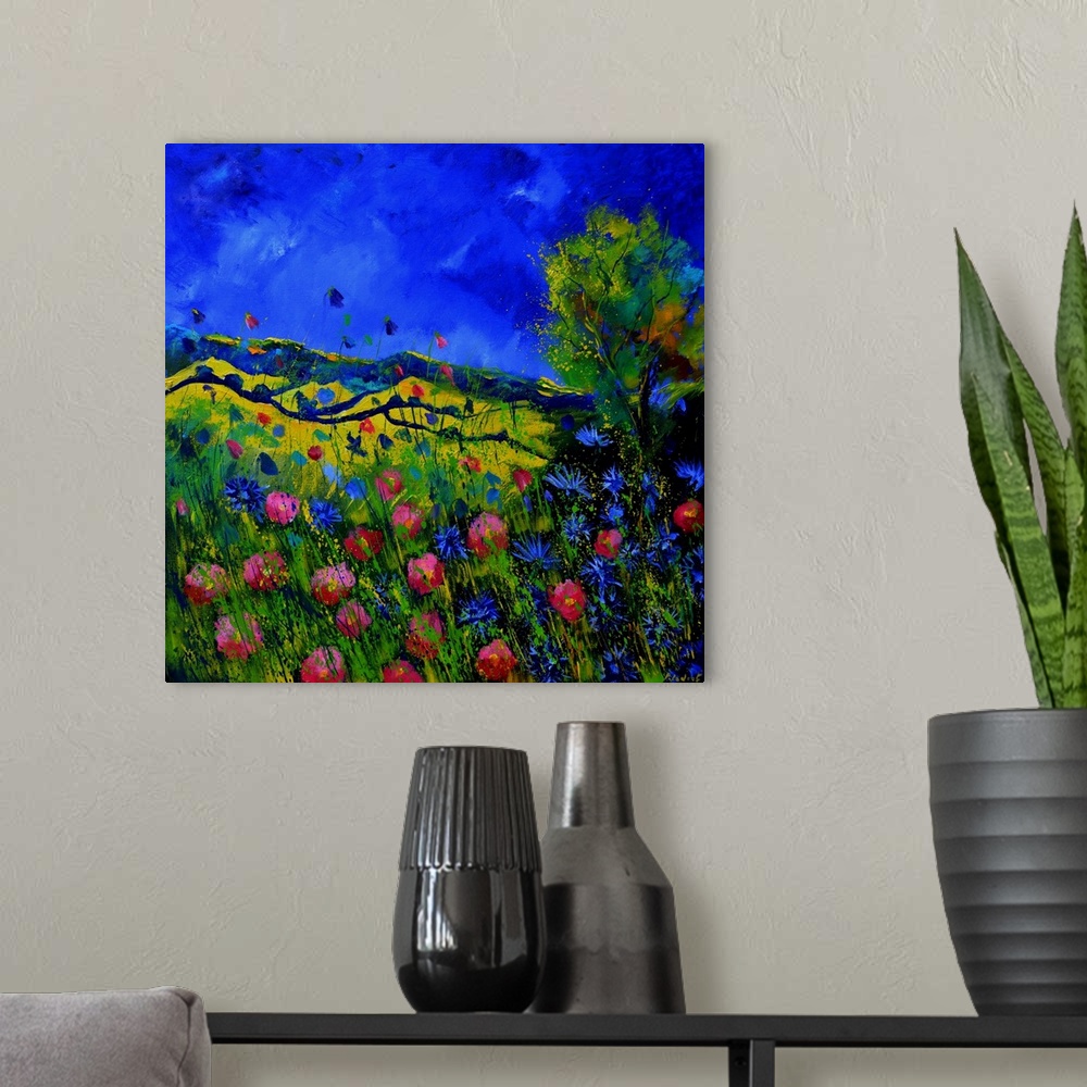 A modern room featuring Vibrant painting of a bright Summer day with blooming flowers, a colorful sky, and rolling hills ...