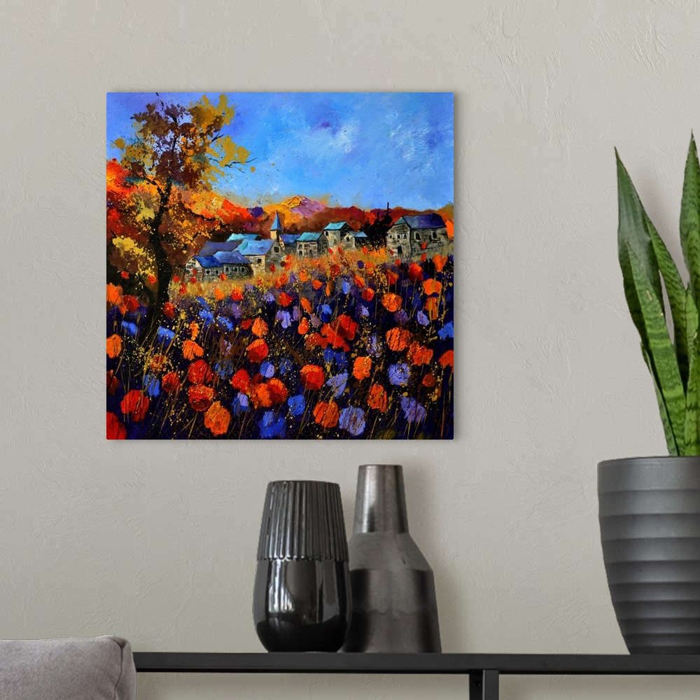 A modern room featuring Vibrant painting of a fall day with blossoming flowers, a colorful sky, and a village in the dist...