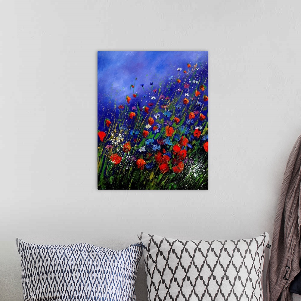 A bohemian room featuring Vertical painting of a field of red and blue wild flowers in bloom with a vibrant blue sky.