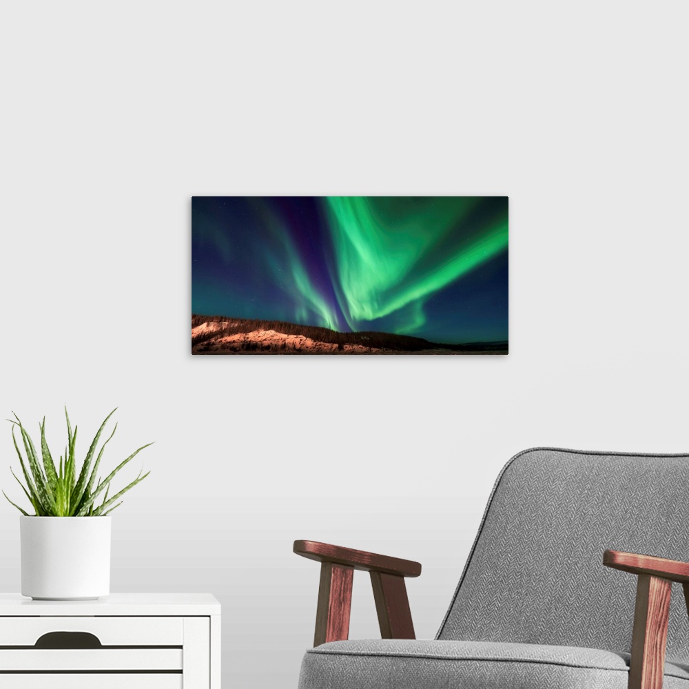 A modern room featuring Northern lights over the frozen Yukon River, Dawson City, Canada