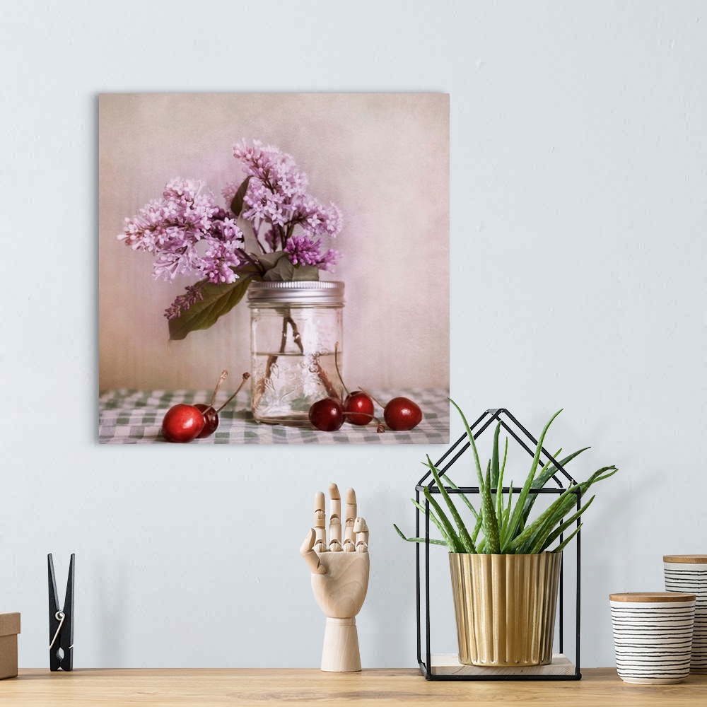 A bohemian room featuring A still life, with lilac blossoms and red cherries