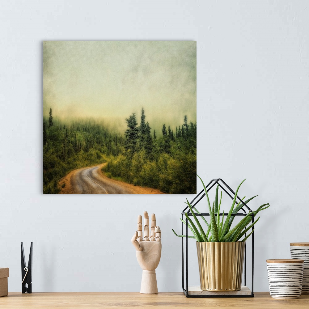 A bohemian room featuring An artistic photograph of a misty foggy view of a forest road.