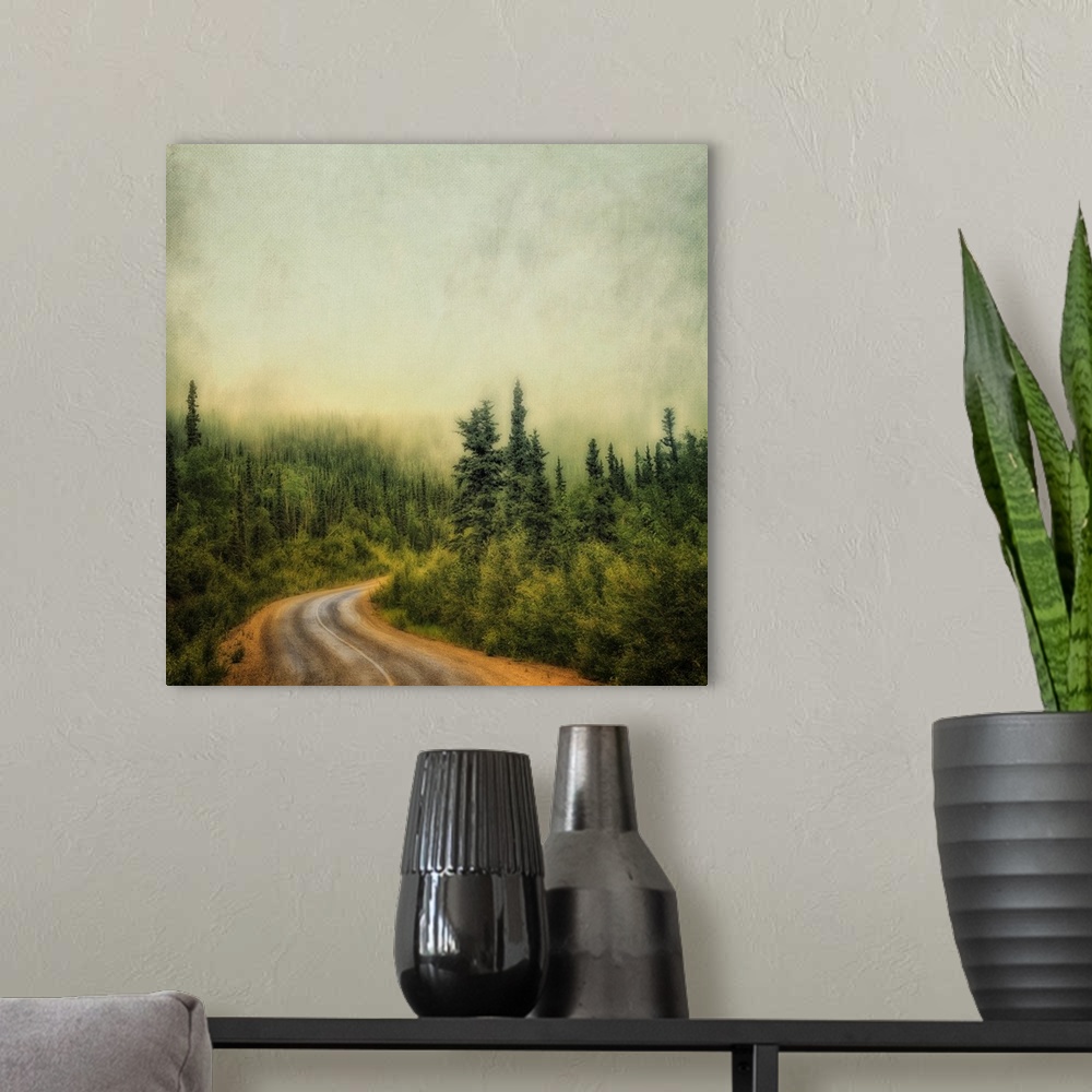 A modern room featuring An artistic photograph of a misty foggy view of a forest road.