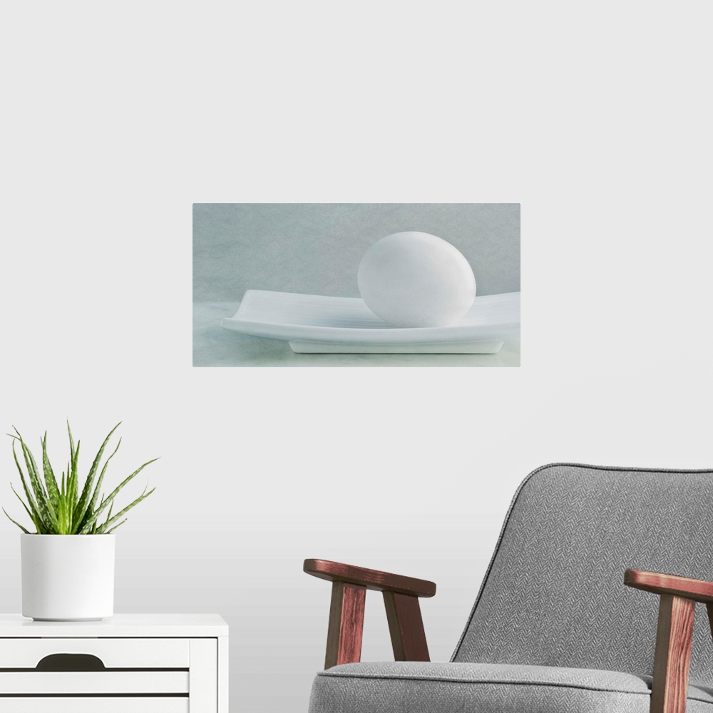 A modern room featuring Simple, soft still life with a white chicken egg in a white dish