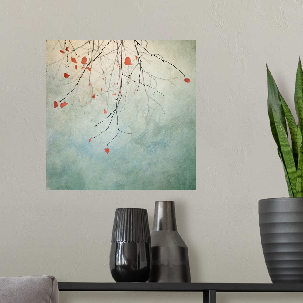 A modern room featuring An artistic photograph of slightly bare tree branches hanging down from the top of the image agai...
