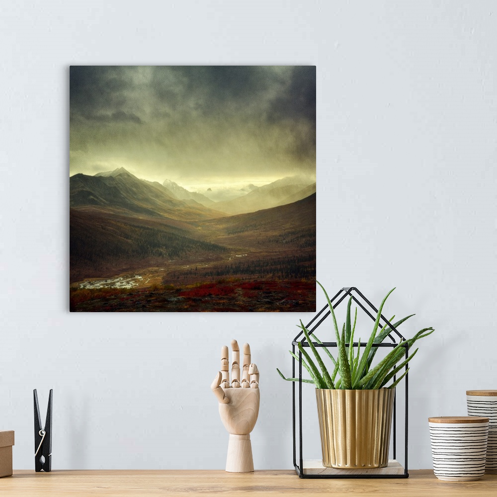 A bohemian room featuring An artistic photograph of a mountain valley under a dark sky.