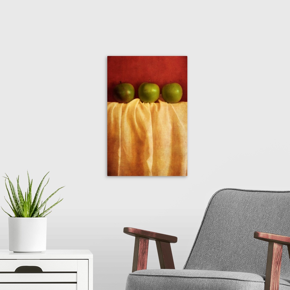 A modern room featuring Still life with three granny smith apples against red background