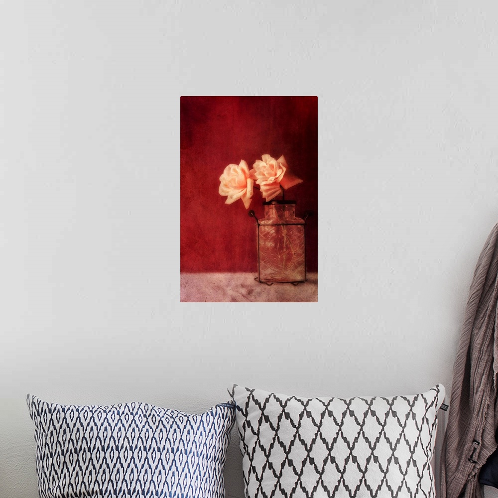 A bohemian room featuring Still life with roses and an old vase against a rich dark red wall, natural light from the window.