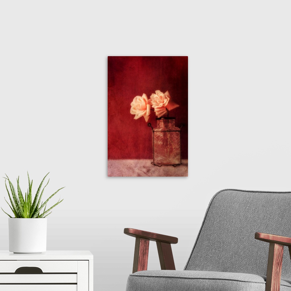 A modern room featuring Still life with roses and an old vase against a rich dark red wall, natural light from the window.