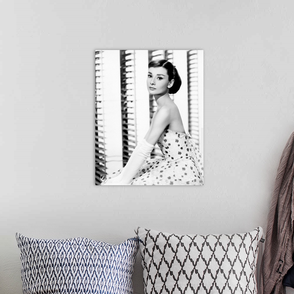 A bohemian room featuring Big, vertical photograph of a side view of Audrey Hepburn sitting in a floral dress and long, whi...
