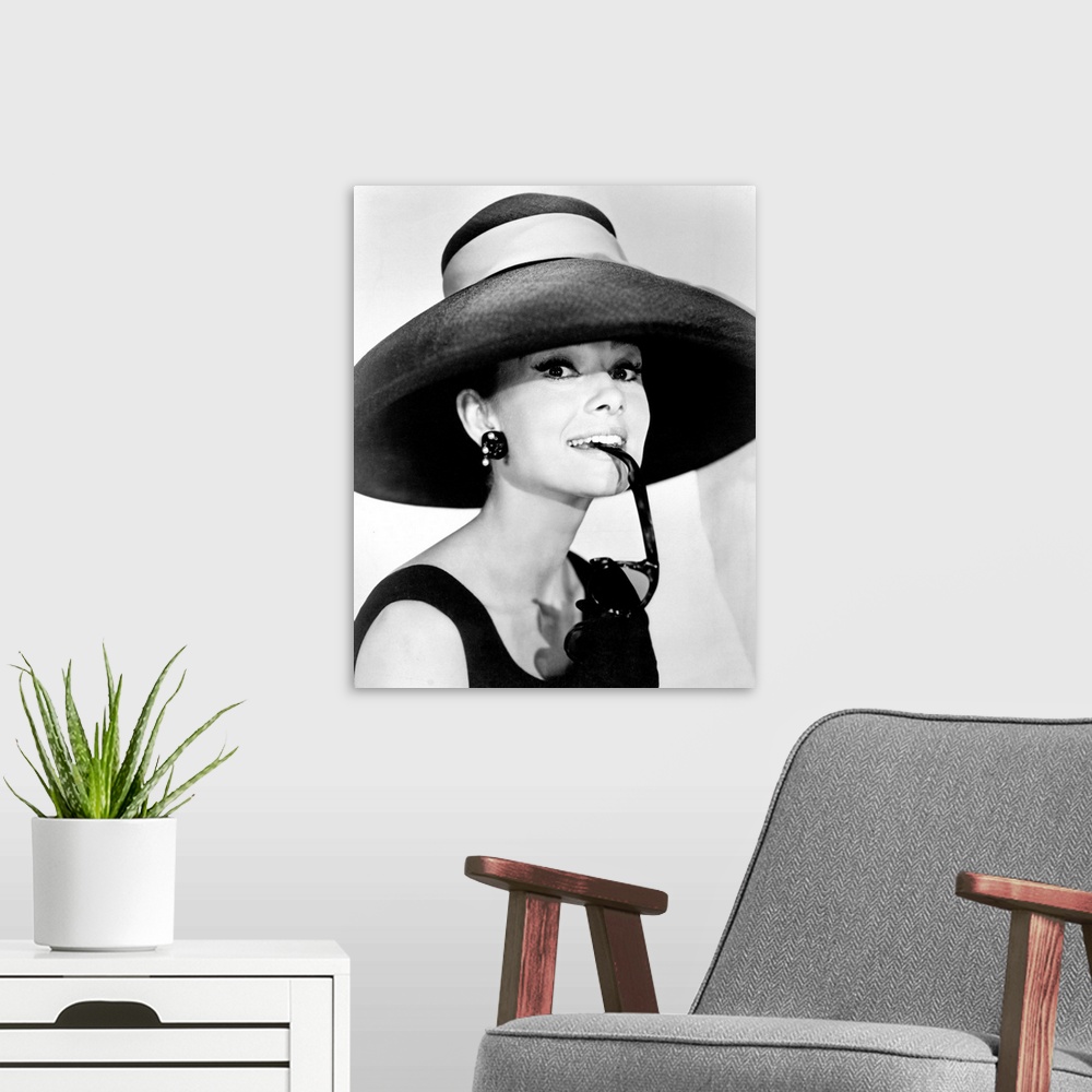 A modern room featuring Large photograph of Audrey Hepburn in a giant sun hat holding sunglasses in her mouth as she glan...