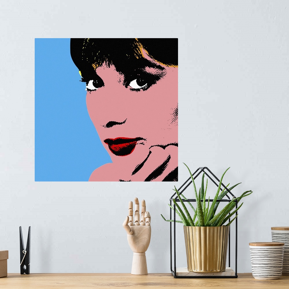 A bohemian room featuring Retro artwork of Audrey Hepburn where only her face and hand holding it up are shown.
