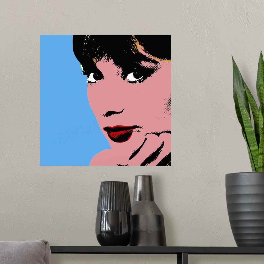 A modern room featuring Retro artwork of Audrey Hepburn where only her face and hand holding it up are shown.