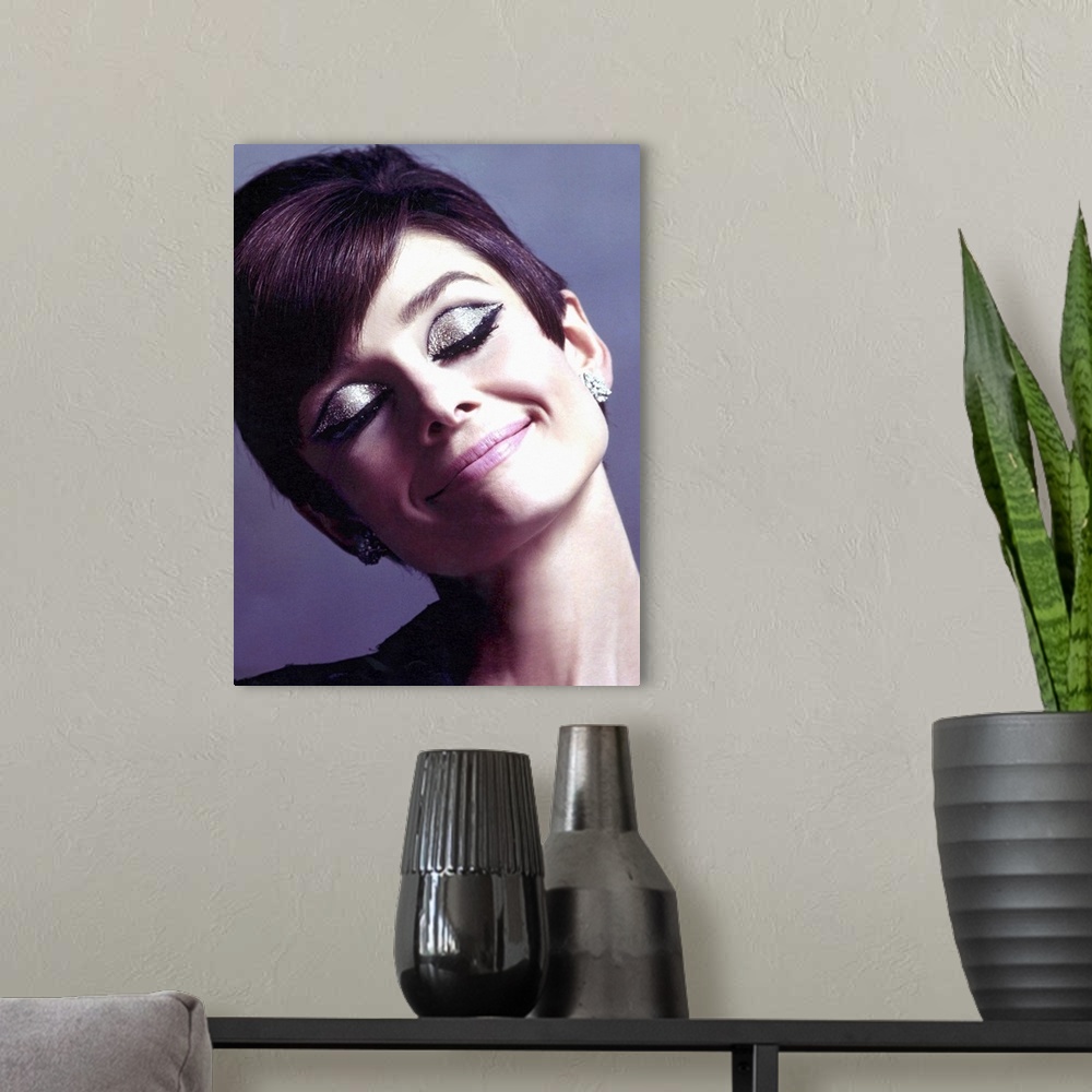 A modern room featuring Canvas photo art of Audrey Hepburn with sparkling eye make up smiling.