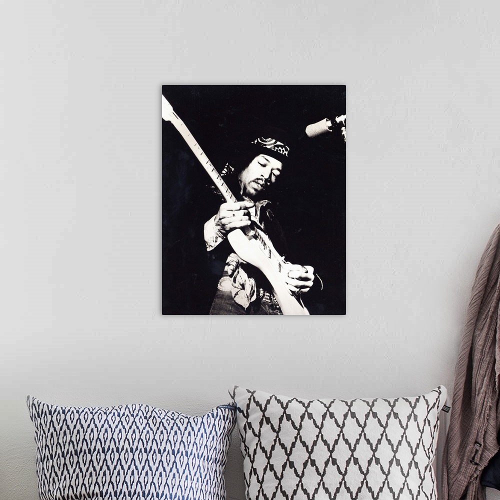 A bohemian room featuring Old black and white photograph of Jimi Hendrix playing the guitar live.