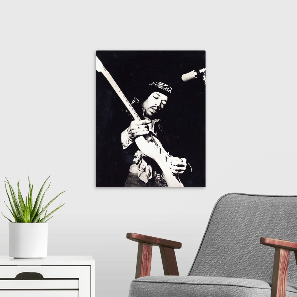 A modern room featuring Old black and white photograph of Jimi Hendrix playing the guitar live.