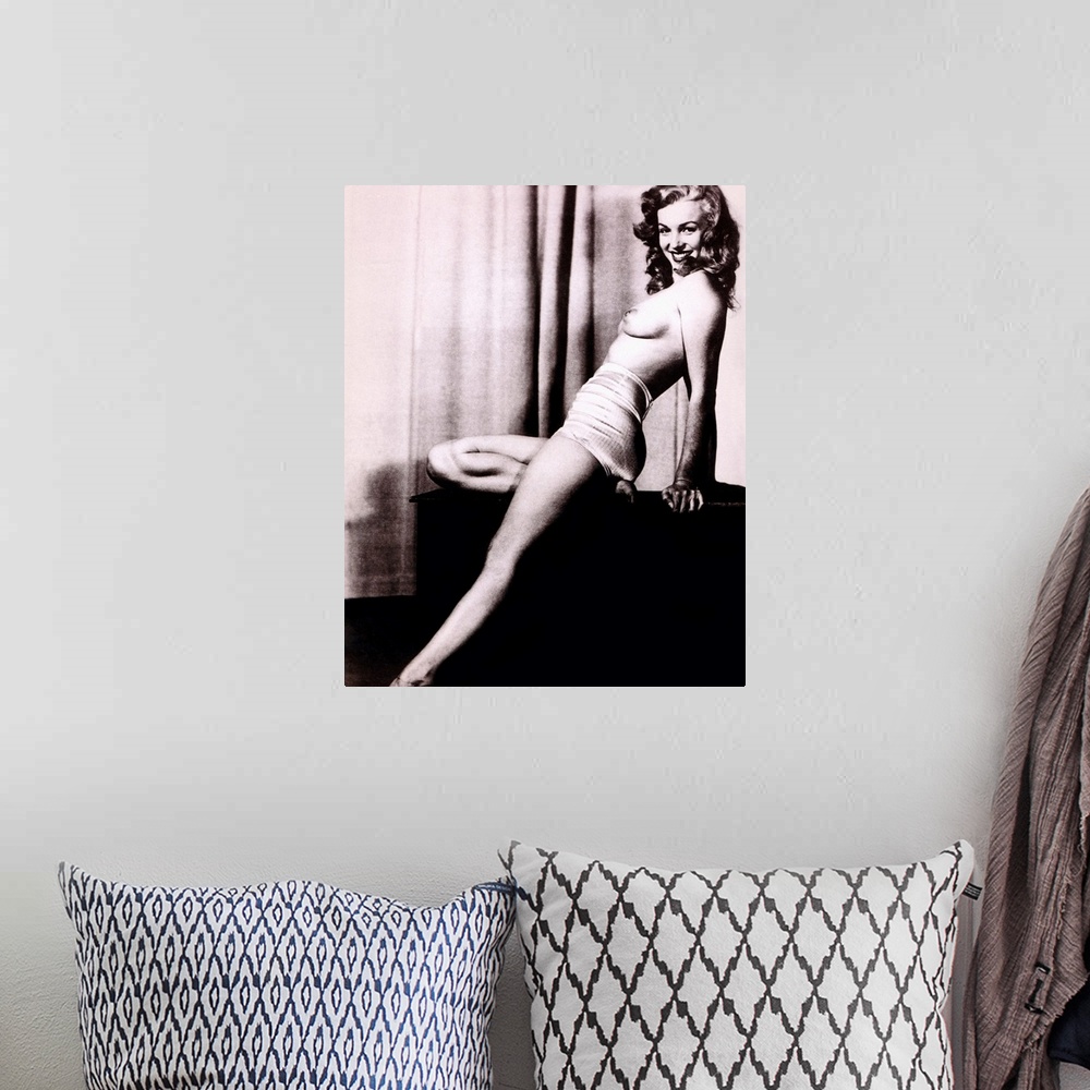 A bohemian room featuring Boudoir photo of Marilyn Monroe topless and leaning back on a stand in front of a curtain, smilin...