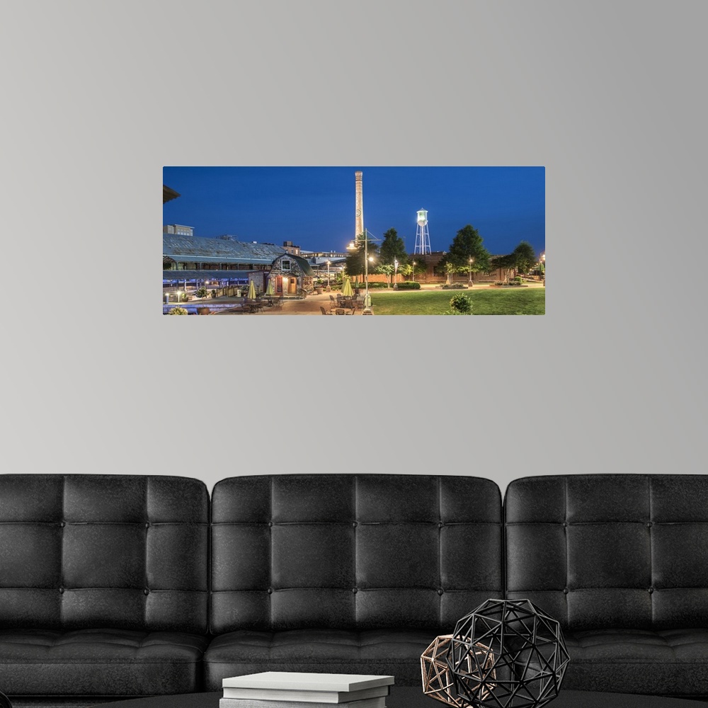 A modern room featuring Lucky Strike Water Tower and Smokestack over the brick factory buildings at night, American Tobac...