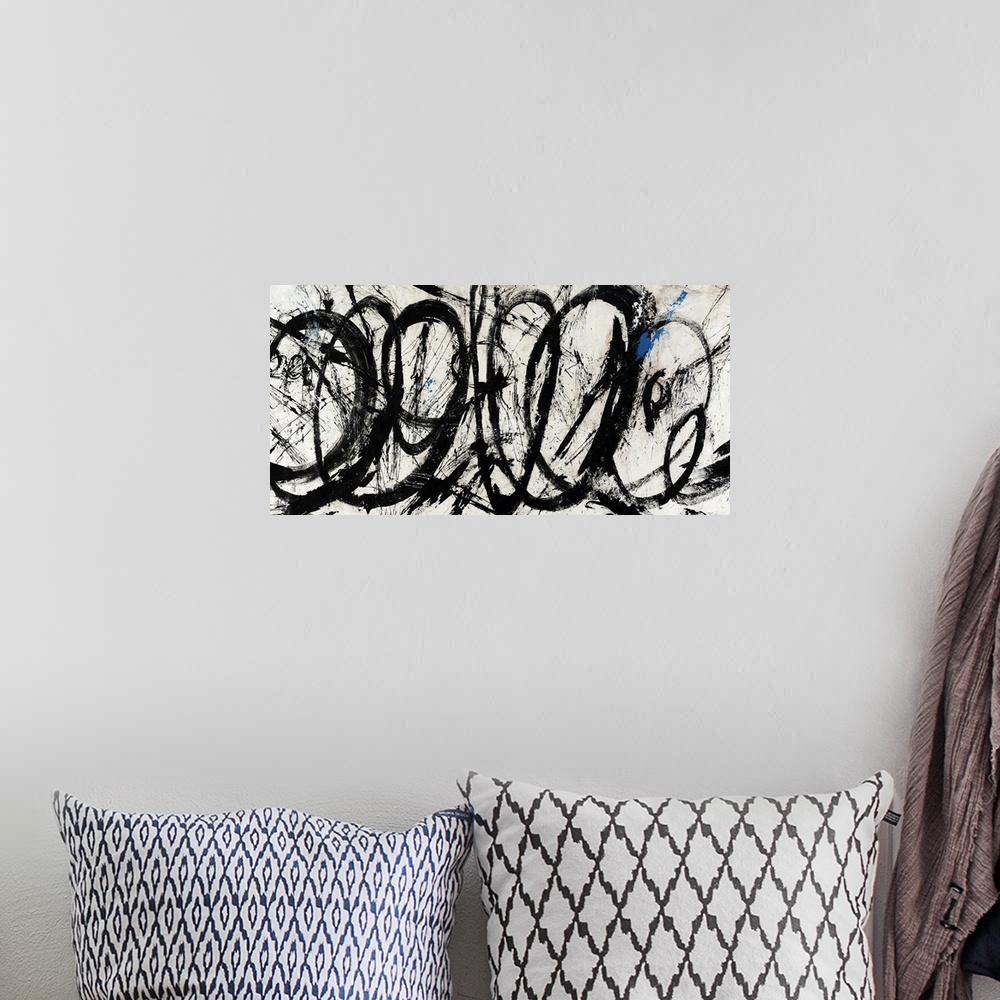 A bohemian room featuring An abstract piece of artwork that has swirls of black paint throughout the panoramic print.