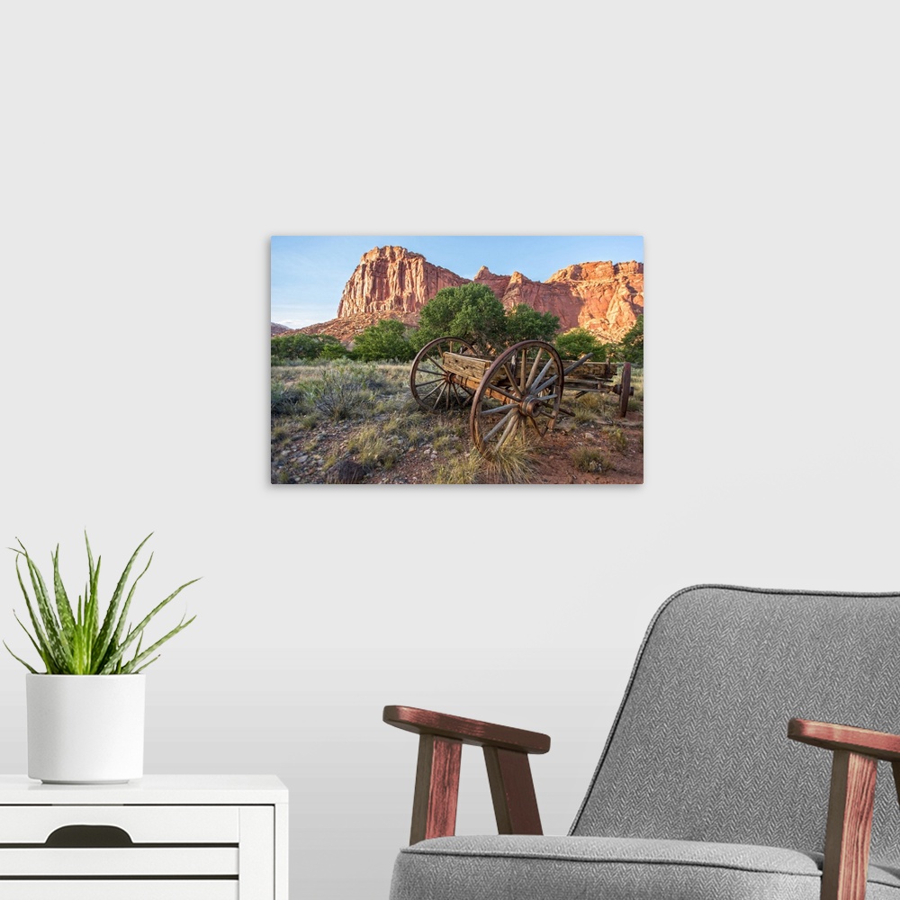 A modern room featuring An antique wagon under Fruita's rock formations in Capitol Reef National Park, Utah.