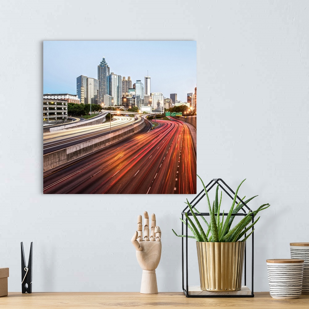 A bohemian room featuring Light trails on the street from passing vehicles leading towards the city skyline of Atlanta, Geo...