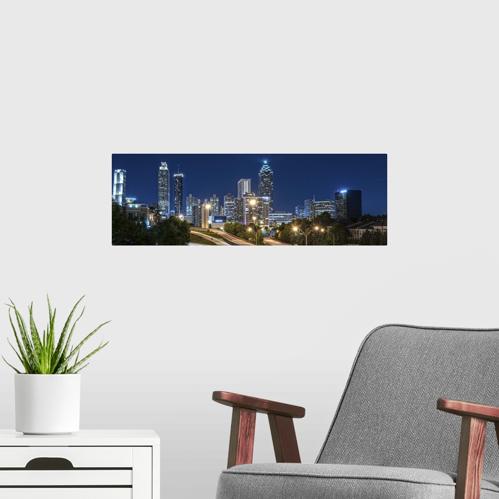 A modern room featuring Panoramic photo of the city skyline of Atlanta, Georgia, illuminated at night against a deep blue...