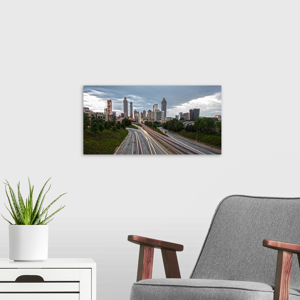 A modern room featuring Skyscrapers in the Atlanta, Georgia skyline and light trails from passing cars on the roads in th...