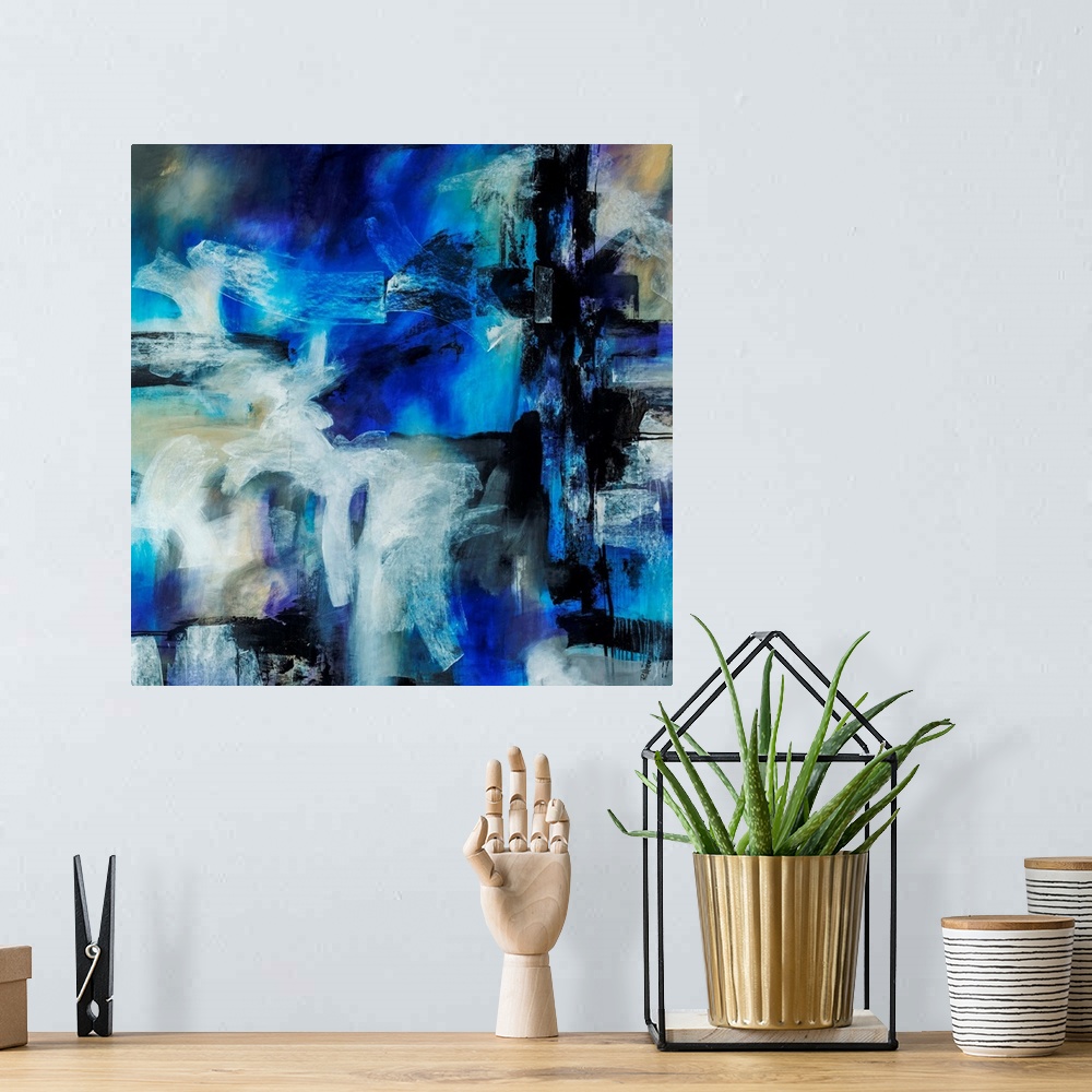 A bohemian room featuring Abstract artwork painted with bright blue tones underneath thick black and white brushstrokes.