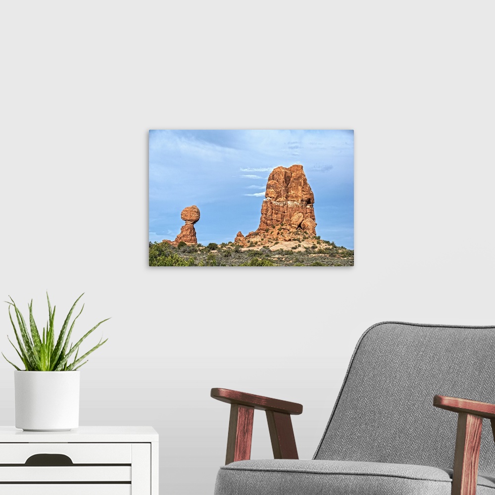A modern room featuring Balanced Rock standing next to a sandstone rock formation under a cloudy sky, Arches National Par...