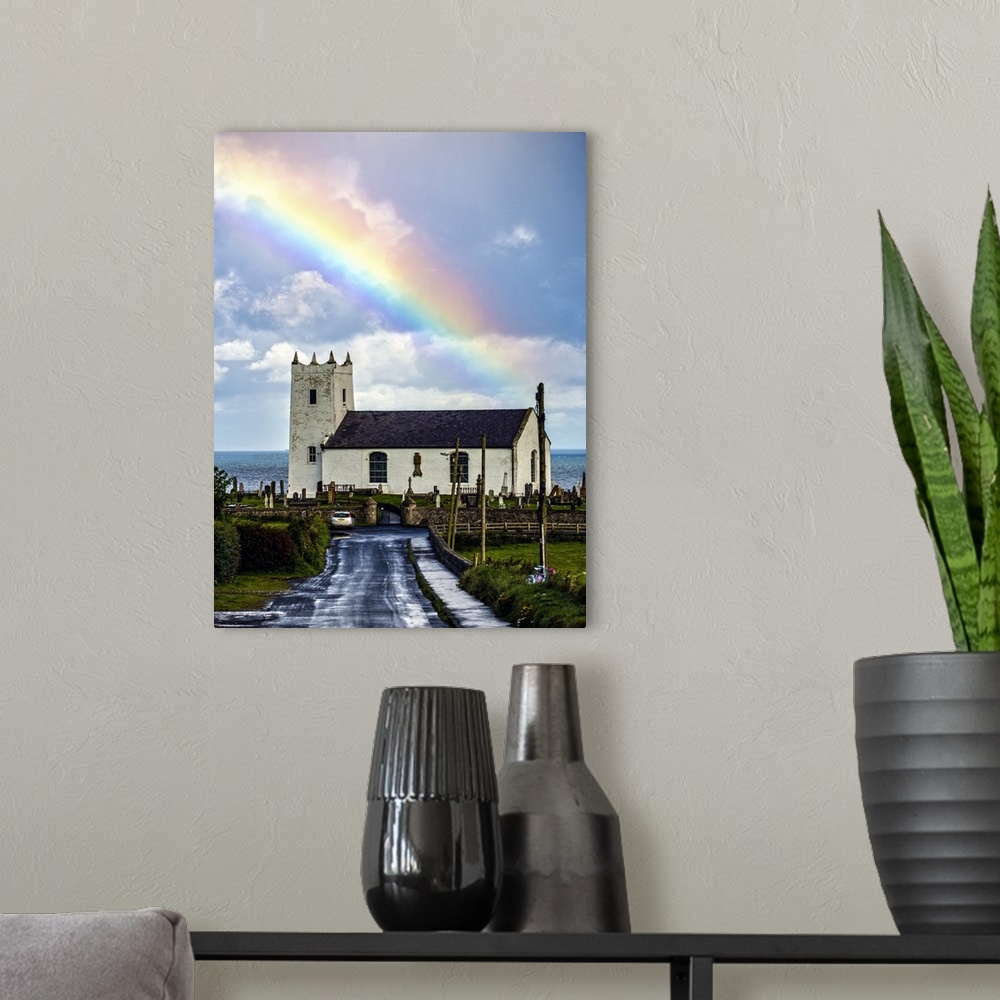 A modern room featuring Photograph of Ballintoy Parish Church with a beautiful rainbow behind it over the ocean, at Balli...