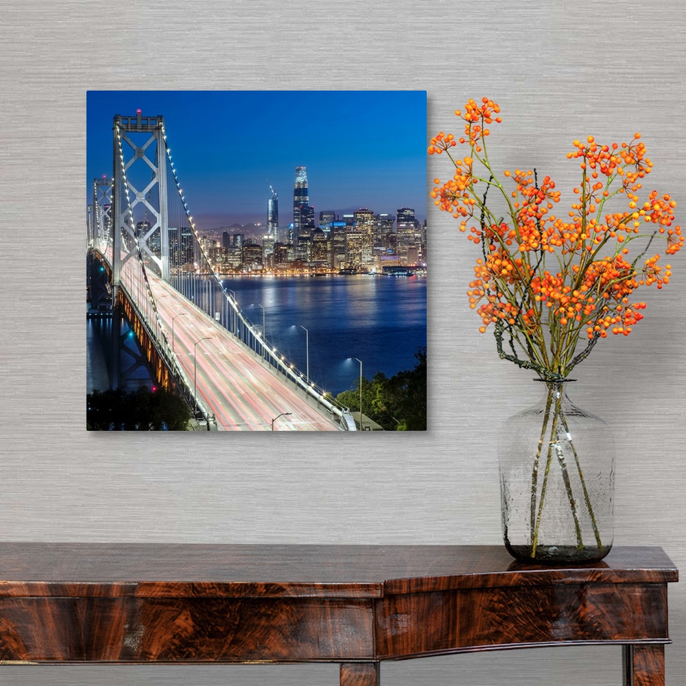 A traditional room featuring Square photograph of the Bay Bridge at dusk with downtown San Francisco lit up in the background.