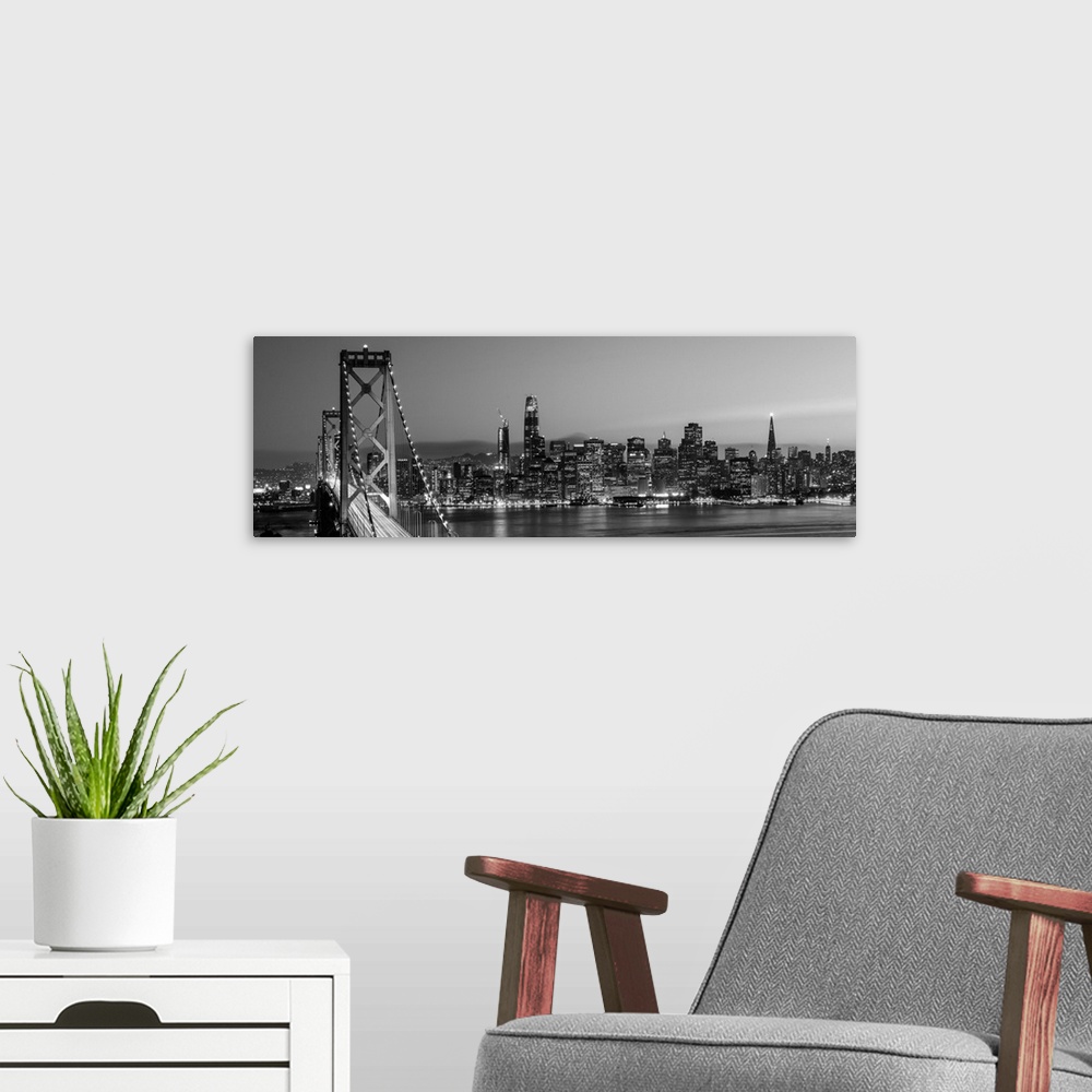 A modern room featuring Photograph of the Bay Bridge and the San Francisco skyline lit up at dusk.
