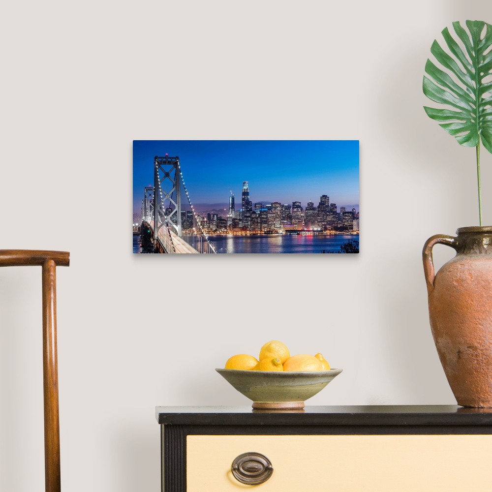 A traditional room featuring Photograph of the Bay Bridge and the San Francisco skyline lit up at dusk.
