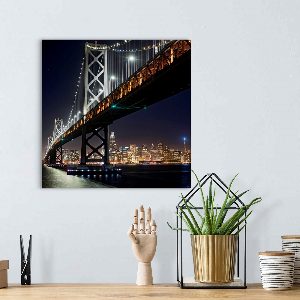 A bohemian room featuring Square photograph of the Bay Bridge lit up at night with the San Francisco skyline in the backgro...