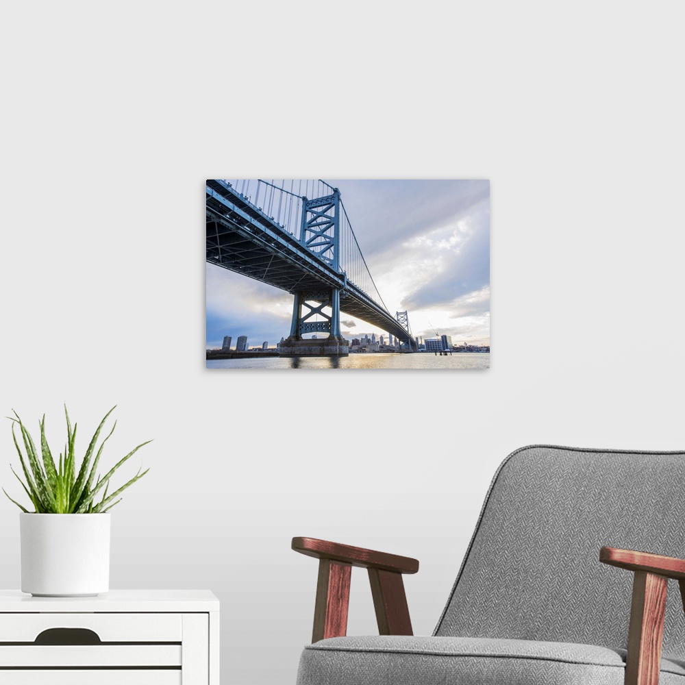 A modern room featuring View of one of the towers of the Benjamin Franklin Bridge in Philadelphia, under a cloudy sky.