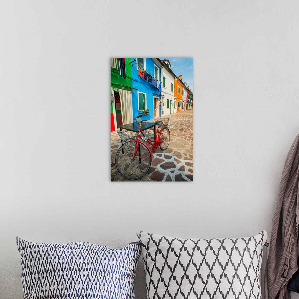 A bohemian room featuring Photograph of a red bicycle leaning on a table outside of a row of vibrant fishermen's homes in B...