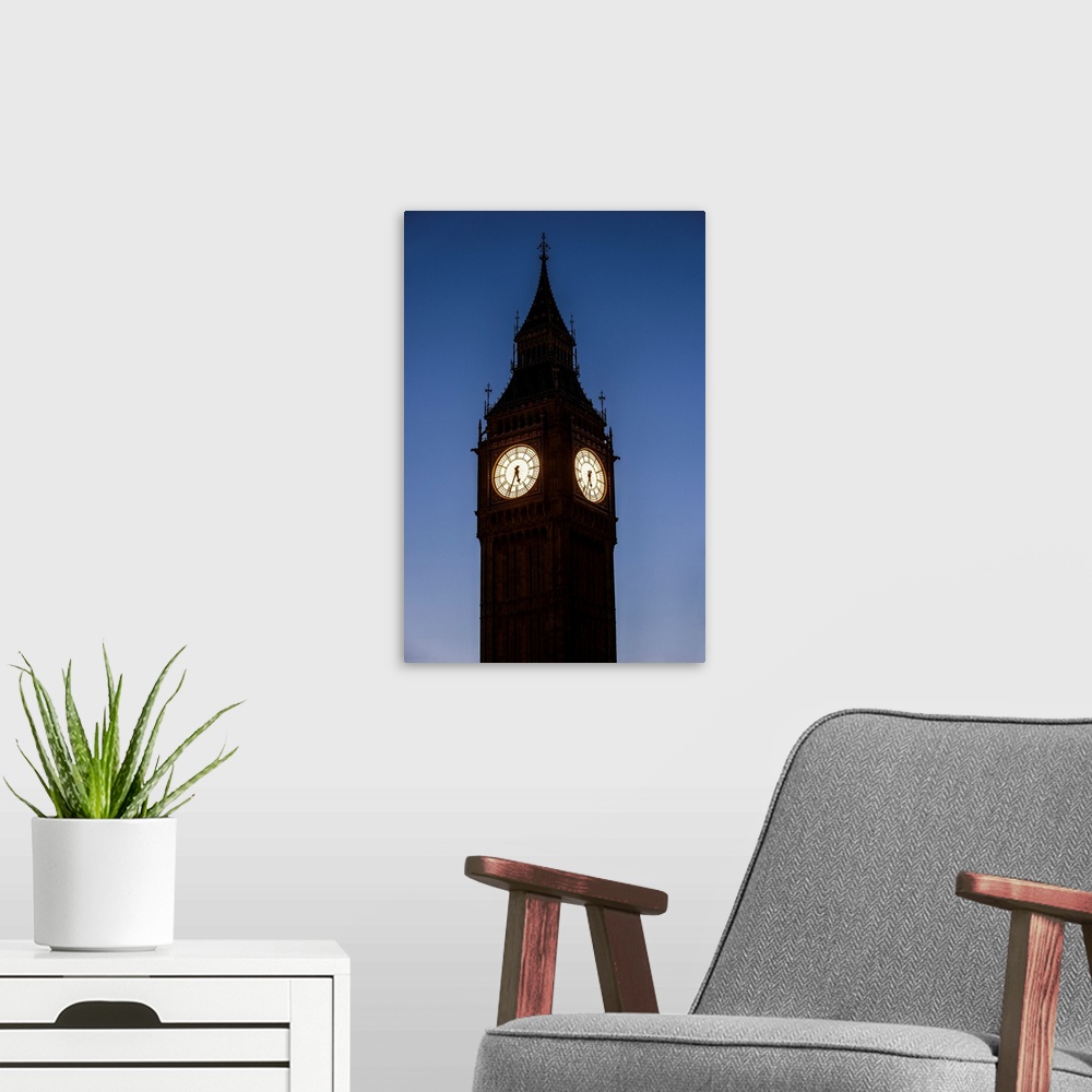 A modern room featuring View of a famous clock tower called Big Ben in London, England at night.
