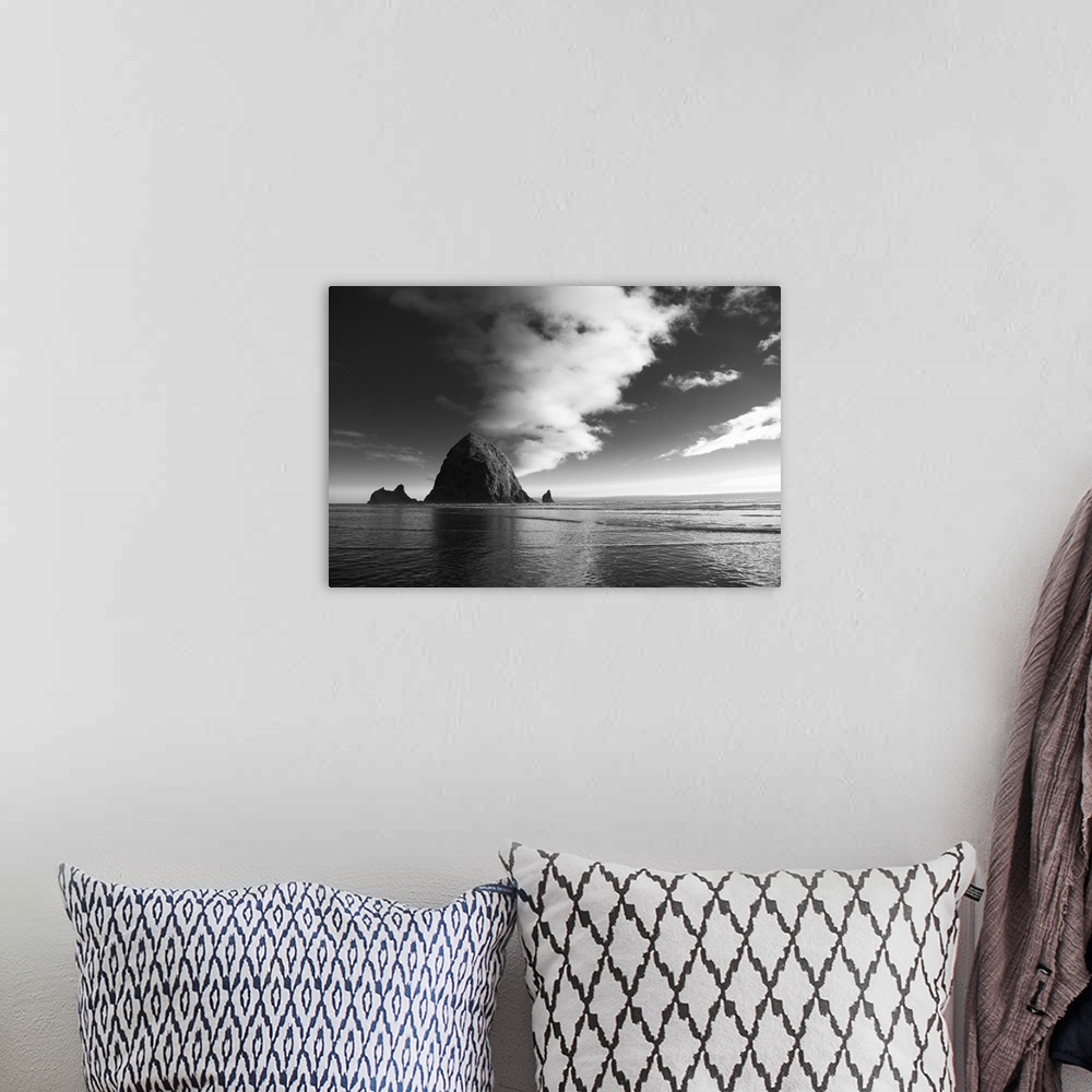 A bohemian room featuring Black and white photograph of Haystack Rock with rippling waters.