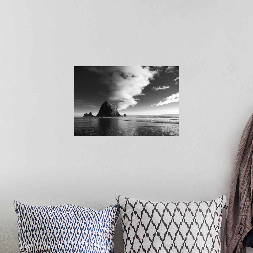 A bohemian room featuring Black and white photograph of Haystack Rock with rippling waters.