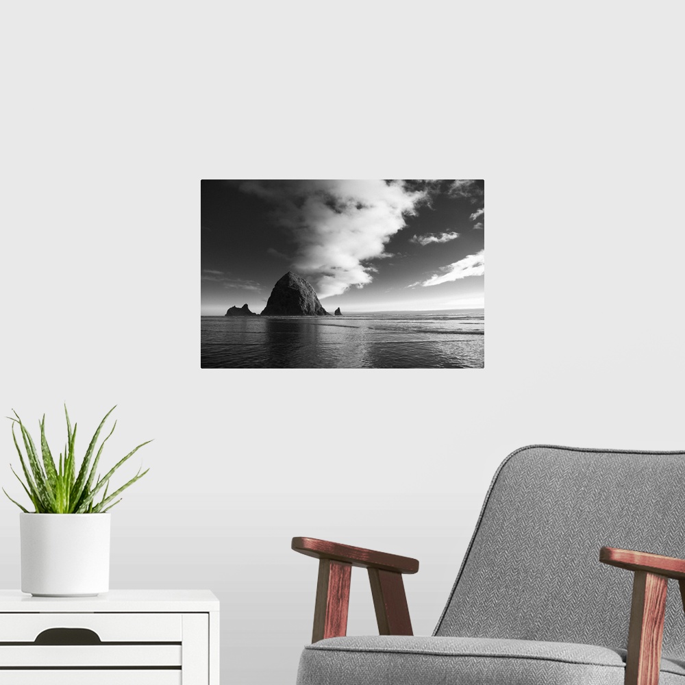 A modern room featuring Black and white photograph of Haystack Rock with rippling waters.